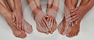 Close up of well groomed hands with manicure on female feet of mature women isolated over white background