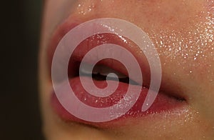 Close-up of wet nature lips. Lips with gloss makeup. Filler Injections, Plastic Surgery, Collagen and Treatments.