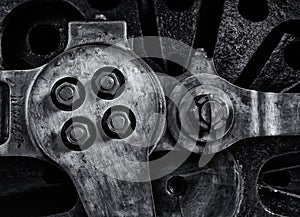 Close up of the wheel and coupling rods of an old steam locomotive with textured metal surface and bolts