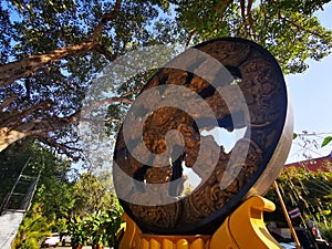 close up of Wheel of Dharmachakra in front of temple, Thailand