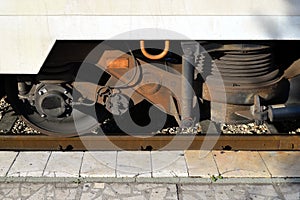 Close up of wheel and springs of a passenger car on a railway platform