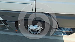 Close-up of wheel of truck moving on highway traffic, road