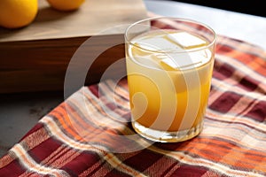 close up of a whiskey sour cocktail with a patterned napkin underneath