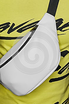Close-up white, abstract, waist or shoulder bag, object, attribute of style and fashion on a bright yellow background