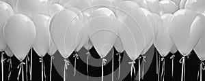 Close up of white balloons isolated on black background, wide panoramic design for website banner or flier, usable as header.