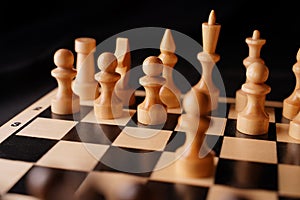 Close up of white and black chess pieces on board. Selective focus on first move of white pawn on chessboard. Concept of