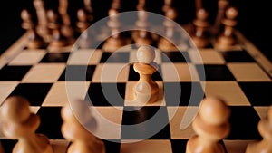 Close up of white and black chess pieces on board. Selective focus on first move of white pawn on chessboard. Concept of