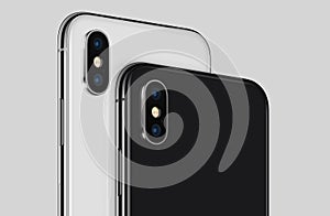 Close-up white and black rotated smartphone similar to iPhone X back sides with camera modules cropped photo