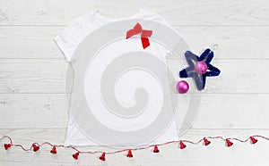 Close up white blank template t shirt with copy space and Christmas Holiday concept. Top view mockup t-shirt and red bow on white