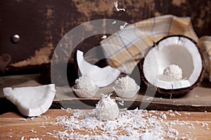 Close up of white candies and coconut with white pulp, coconut chip on wooden background