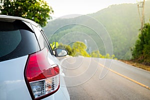 Close up of White car that is stained with mud after rain on mountain road and sunset, Travel and Relaxed