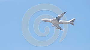 Close up of white cargo airplane passing on blue sky