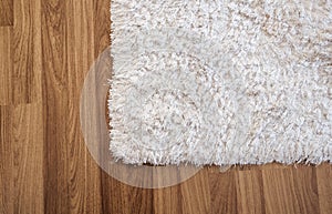 Close-up white carpet on laminate wood floor in living room, interior decoration