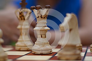 Close up of white chess pieces with focus on queen and king and knight blurred out in background. Concept - idea, strategy