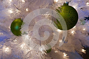 Close up of white Christmas tree with green ornaments