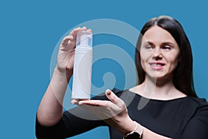 Close-up of white clean tube with cosmetic product in hands of woman