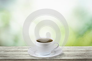 Close up white coffee cup on wood table with nature background and glowing sparkles