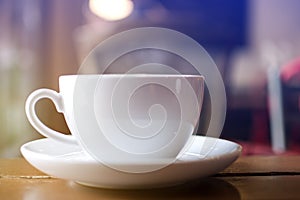 Close up white cup with soft steaming hot coffee on table