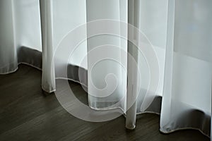 Close-up of the white curtains in the house or hotel. Sun shines through the curtain and through the window.