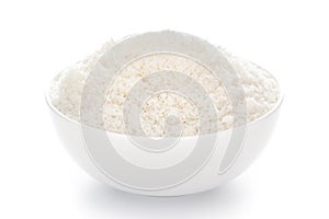 Close-up of white dry  desiccated organic coconut in a white ceramic bowl over white background