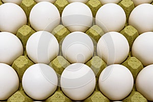 Close-up of white eggs on a carton box