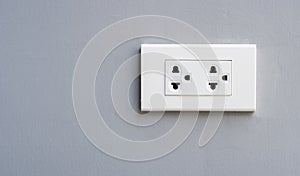 Close-up of white electric outlet in a cement wall in house interior