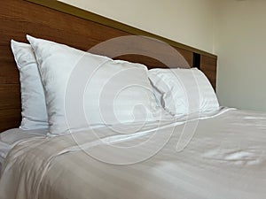 Close up white fluffy pillows on double bed