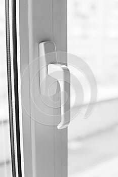 Close-up on a white handle of the pvc window.