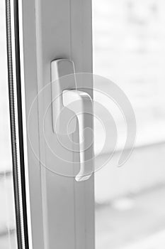 Close-up on a white handle of the pvc window. photo