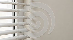 Close-up of White Horizontal Window Blinds Casting Shadows on a Light Beige Wall 120304