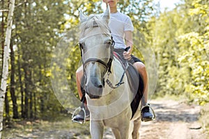 Close up of white horse running with teenage rider boy