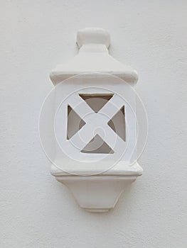 Close up of white lantern hanging on cement wall. Exterior lighting. Outdoor lamp. Construction and architectural details