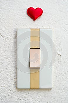 Close up of white light switch with a red heart