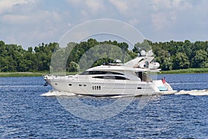 Close-up of white luxury yacht in motion on the Dniepr River, side view