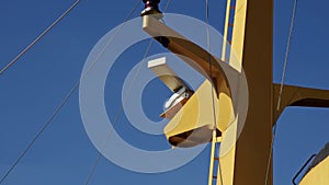 Close up white marine radar rotates on yellow mast of ship traveling on water surface on voyage. Rotating X band marine