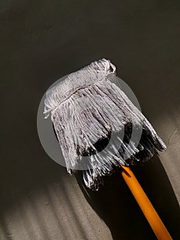 a white mop with an orange handle