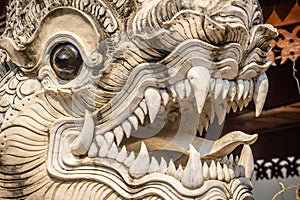 Close up white naga heads open mouth with white fangs in Thai's style patterned in Buddhist temple. Scary white head of the serpe