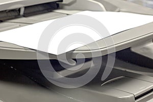 Close-up white paper sheets on the printer in office