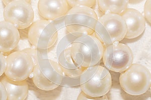 close up of white pearl necklace on an ivory fabric