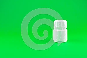 Close up white pill bottle on lime green background with copy space. Focus on foreground, soft bokeh. Pharmacy drugstore concept