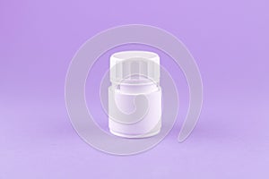 Close up white pill bottle on purple background with copy space. Focus on foreground, soft bokeh. Pharmacy drugstore concept