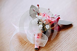 Close up of white and pink rose boutonniere.