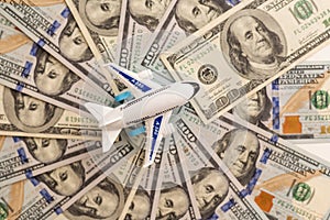 Close-up white plane toy on dollar bill background. Concept of traveling