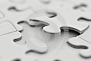 Close-up of a white puzzle missing one piece photo
