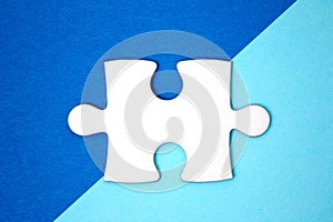 Close up white puzzle piece over a geometry blue background