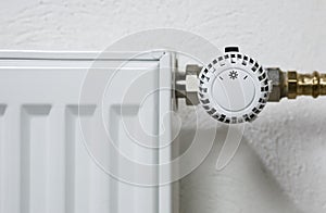 close up of white radiator thermostat in front of a white wall
