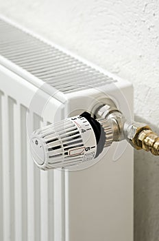 close up of white radiator thermostat in front of a white wall