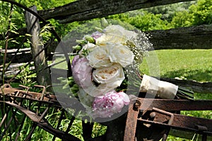 Close up of White Rose and Pink Peonies Wedding Bouquet on Rusty Farm Equipment