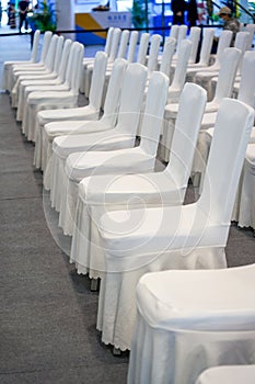 Close-up of white satin chair seats for large business meeting