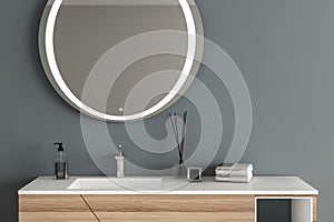 Close up of white sink with oval mirror hanging in on blue wall, modern cabinet with faucet in minimalist bathroom. 3d rendering